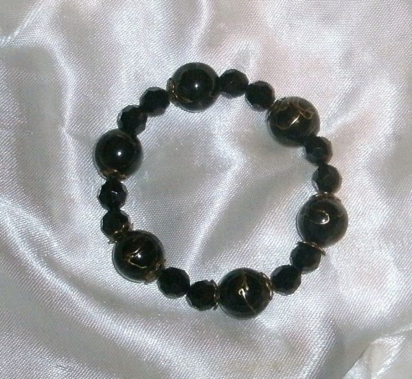 Pulseira preta com detalhes dourado