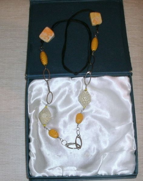 Colar  em fio preto com detalhes amarelo.